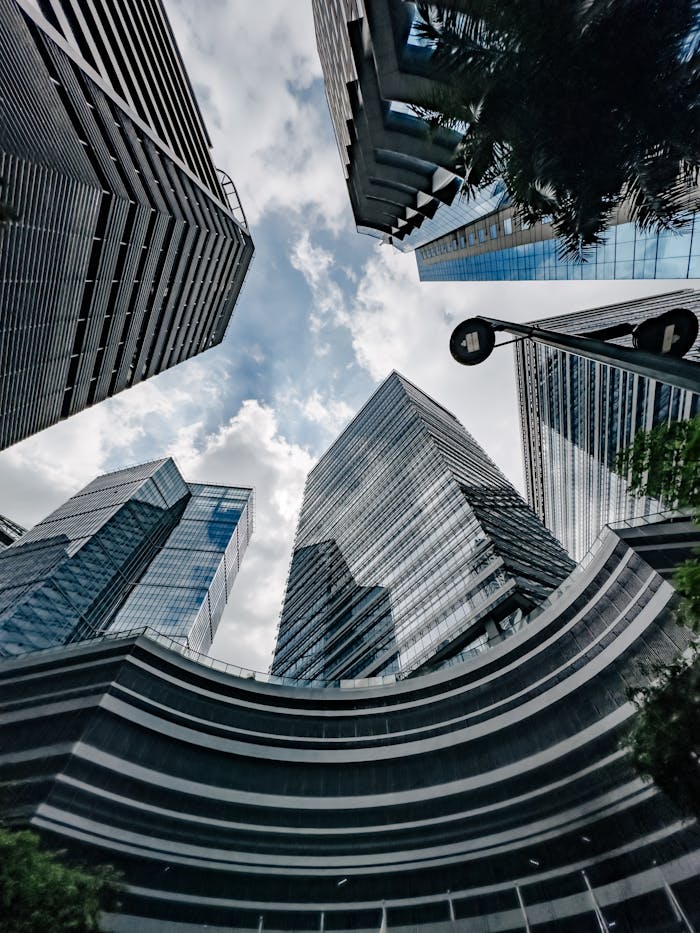 Skyward view of modern skyscrapers with a cloudy sky in Taguig, Philippines.