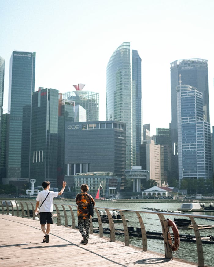 A vibrant day scene showing people walking beside the Singapore skyline.